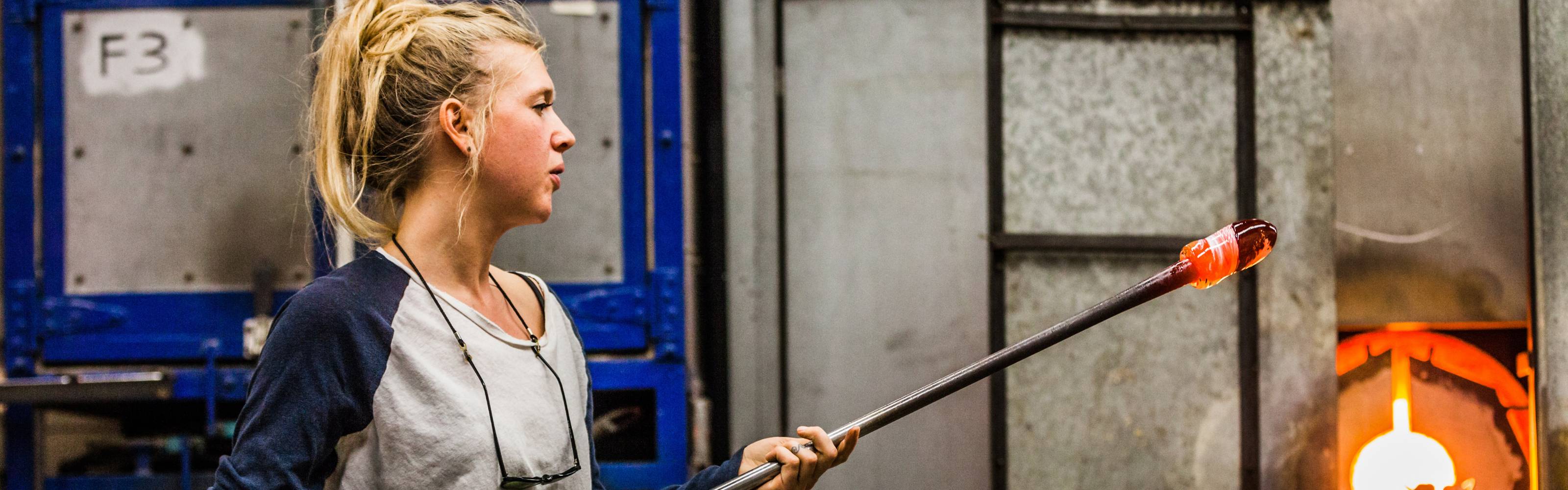 Glassblowing artisan shaping molten glass at a furnace, American craftsmanship, Rep America About page hero, desktop